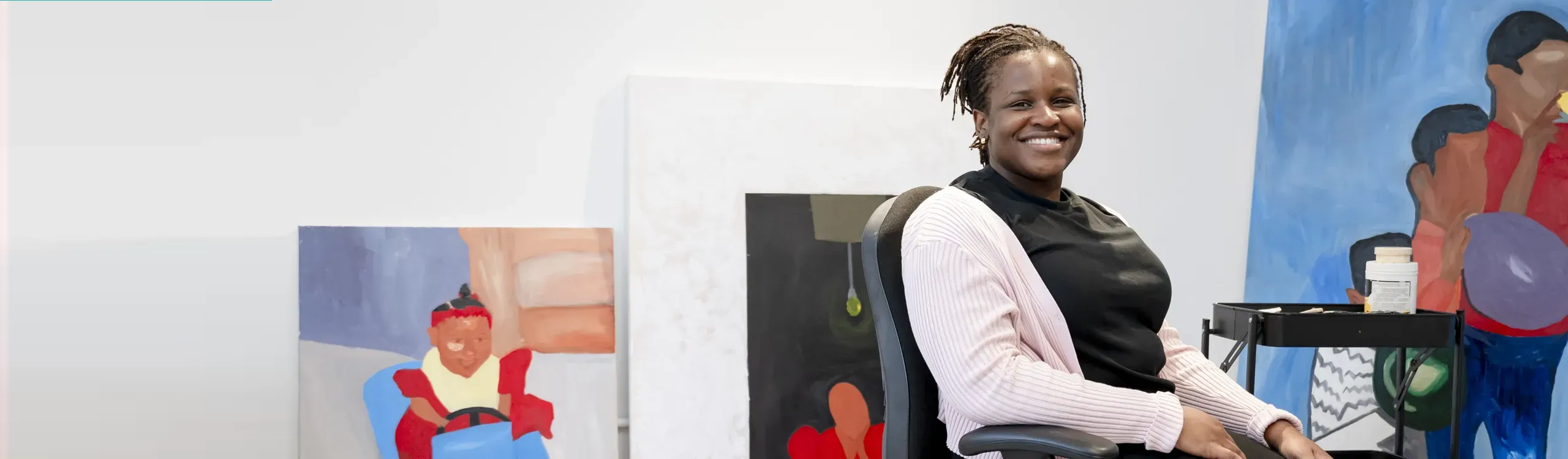 One of the Creative Land Trust artists with her paintings